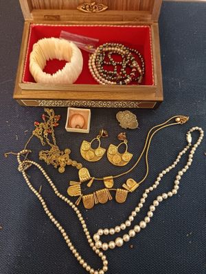 une boîte en bois contenant tout un tas de bijoux