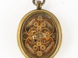 a gold locke with a picture of a clock inside of it