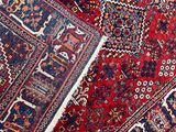 an image of a red rug with a blue border on a white floor
