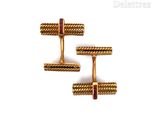 two pairs of gold cufflinks with red stones on them
