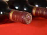 several bottles of wine are lined up on a red cloth
