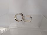 two wedding rings in a clear box on a table