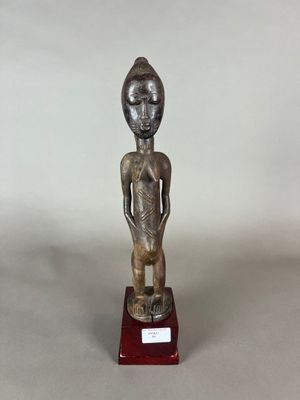 une image représentant une statue d'une personne debout sur un socle rouge