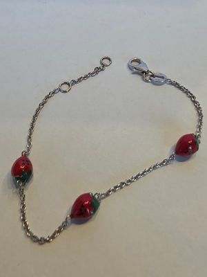 un gros plan d'un bracelet rouge et vert posé sur une surface blanche