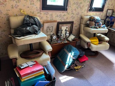un salon où le sol est encombré d'objets