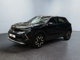 Un SUV noir est garé dans une pièce aux murs blancs.