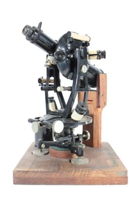 un vieux microscope posé sur un socle en bois, avec un fond blanc