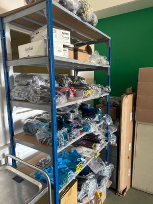 une étagère métallique sur laquelle sont posés de nombreux objets, dans une pièce