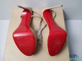 pair of red high heeled shoes in a box on a table