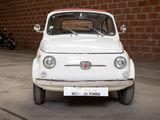 a small white car parked in front of a brick wall