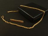 an image of a gold chain and a black box on a black surface