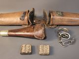 an old pair of leather holsters and a pair of metal studs
