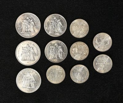 six types différents de pièces d'argent sur une surface noire