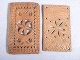 paire de plaques en bois sculptées représentant des fleurs et des feuilles sur fond blanc