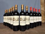 several bottles of wine are lined up on a wooden table