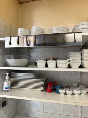 beaucoup d'assiettes et de bols sur les étagères de la cuisine