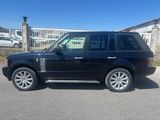 a black land rover parked in a parking lot next to a building