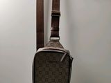 a small brown bag hanging on a wall next to a wooden hanger