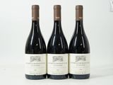 trois bouteilles de vin posées sur une table blanche
