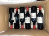 six bottles of red wine in a cardboard box on a table