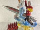 a figurine of a man and a woman riding on a rocket