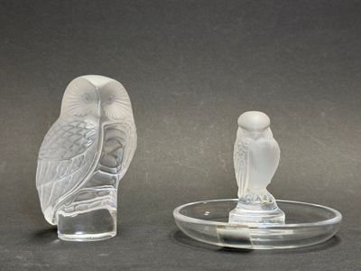 deux figurines en verre représentant des chouettes posées sur un plateau en verre
