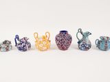 five different colored vases sitting next to each other