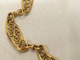 a close up of a gold necklace on a white cloth