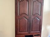 a wooden armoire in the corner of a room