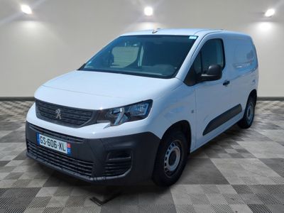 une camionnette blanche garée sur un sol en damier dans une pièce