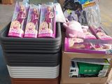 a pile of barbie dolls on a pallet in a warehouse