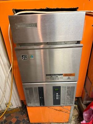un réfrigérateur argenté et orange dans un coin de la pièce