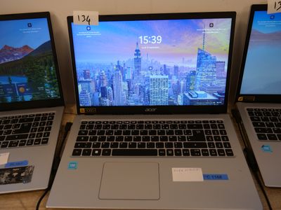 three laptops sitting side by side on a table with a city view on the screen
