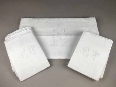 three white towels with embroidered monograms on them on a table