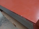 an image of a red desk with a drawer underneath it