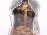 a bottle with a cross inside of it on a white surface