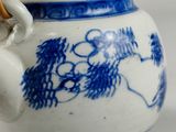 a blue and white tea pot with bamboo sticks in it