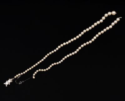 un gros plan d'un collier de perles sur fond noir