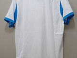 a white and blue shirt hanging on a hanger on a wall