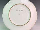 a white plate with a gold rim sitting on a table