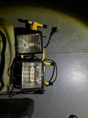 two lights that are sitting on the floor next to a bag