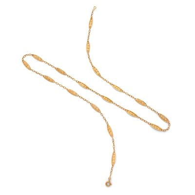 un collier en or composé d'une longue chaîne et d'un pendentif en perle
