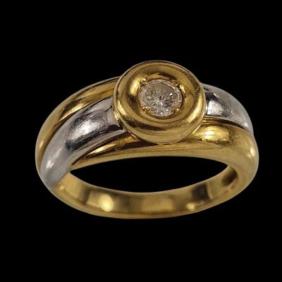 un gros plan d'une bague en or et en argent sertie d'un diamant