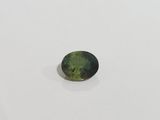a green tourmaline gemstone on a white surface