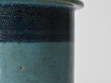 a close up of a blue and green vase on a table