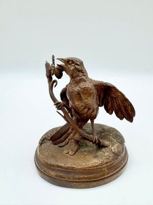 statue représentant un oiseau perché sur une branche, une fleur dans le bec