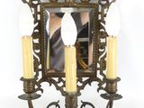 a picture of a wall sconce with three candles and a mirror