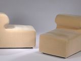 pair of modern chairs with curved backrests on a white surface