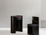 two black chairs and a table in a white room