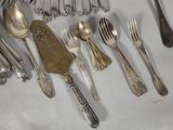a lot of silver spoons and forks on the table